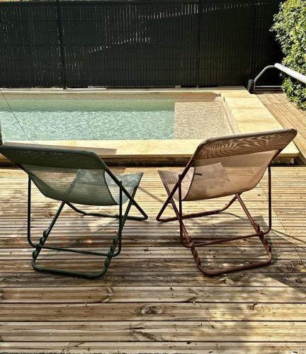une paire de chaises assises à côté de la piscine dans l'établissement Clos de la Noria, à Pont-Saint-Esprit