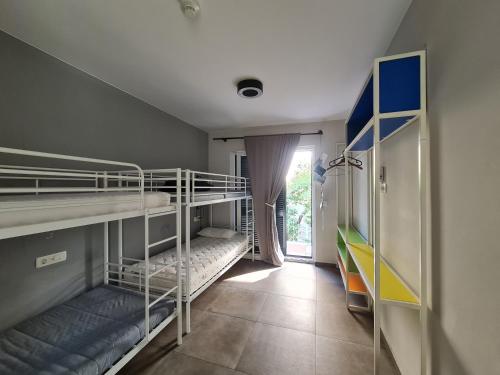 a room with two bunk beds and a window at SUBTUB Hostel Makarska in Makarska