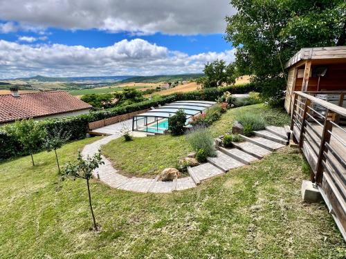 une cour arrière avec une piscine et une maison dans l'établissement Nid d'amour en Auvergne avec piscine, à Le Broc