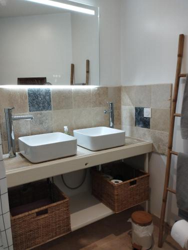 une salle de bain avec deux lavabos et un miroir dans l'établissement gîte Couleur Cuivre, à Cerdon