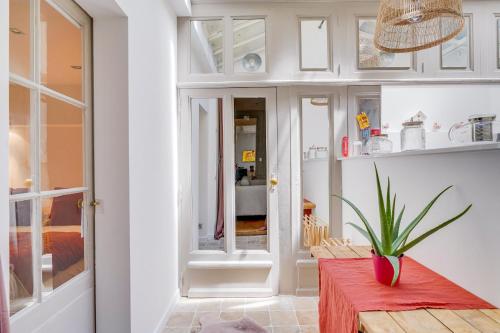 une cuisine avec des placards blancs et une table rouge dans l'établissement Le Départ Bordelais - Appt d'exception Hypercentre, à Bordeaux