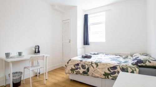 a bedroom with a bed and a desk and a window at Pebbles guest house room 3 in Southampton