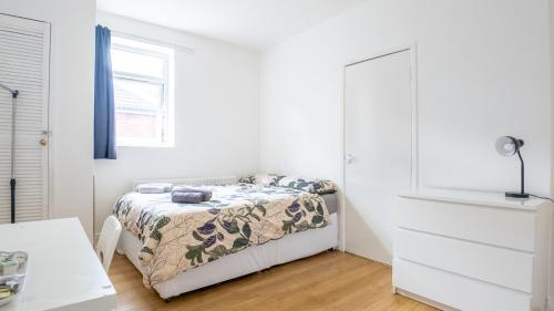 a white bedroom with a bed and a window at Pebbles guest house room 3 in Southampton