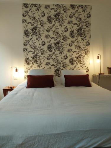 une chambre avec un lit blanc avec deux oreillers dans l'établissement gîte Couleur Cuivre, à Cerdon