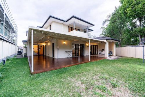 a house with a large deck in a yard at Spacious 5BR 3BA Home w Parking and Yard in Sunnybank M11 in Brisbane