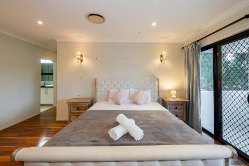 a bedroom with a large bed with two pillows at Spacious 5BR 3BA Home w Parking and Yard in Sunnybank M11 in Brisbane