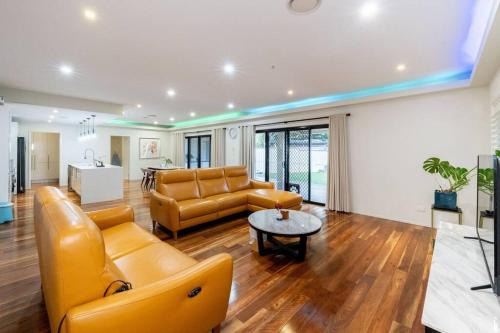 a living room with a couch and a table at Spacious 5BR 3BA Home w Parking and Yard in Sunnybank M11 in Brisbane