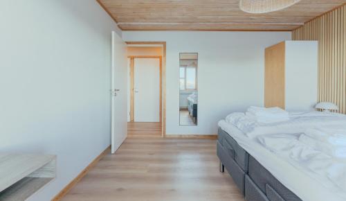 a bedroom with a large bed and a hallway at Á Tromini Guesthouse in Tórshavn