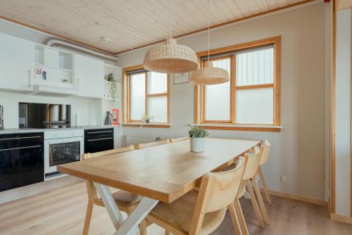 a kitchen and dining room with a wooden table and chairs at Á Tromini Guesthouse in Tórshavn