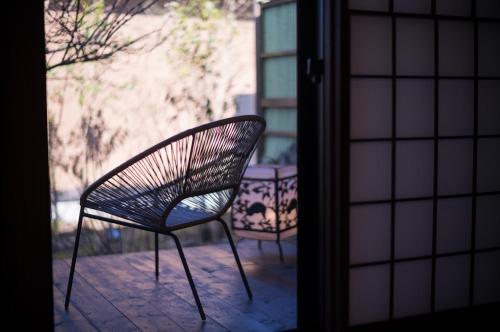a chair sitting on a patio outside a door at Yufuin Kaze no Mori in Yufuin