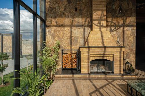 a brick fireplace with a pile of logs in it at RIS Signature Villa Zovuni in Yerevan