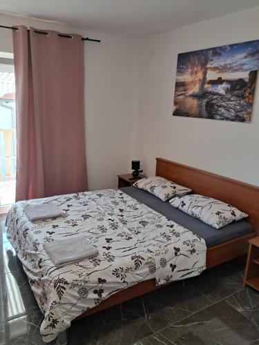 a bedroom with a bed with a comforter at Apartments Mara Bela in Karlobag