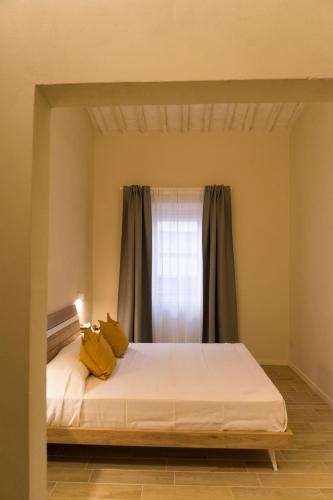 a bedroom with a bed with yellow pillows on it at La Nicchia di Niccolò in Florence