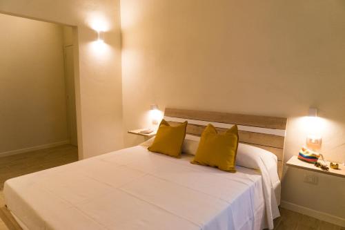 a bedroom with a large white bed with yellow pillows at La Nicchia di Niccolò in Florence