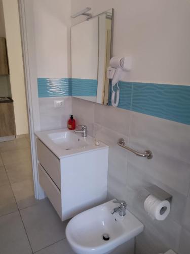 a bathroom with a sink and a toilet and a mirror at Gianola Residence Monolocali Formia in Formia