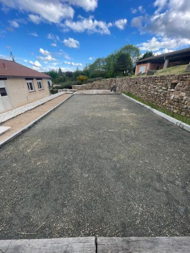 an empty parking lot in front of a stone wall at GÎte VEGA in Mialet