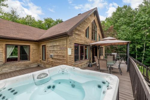 un jacuzzi en la terraza de una casa en Le Rêveur⎮Ski, Spa, Plein-Air et Détente, en Petite-Rivière-Saint-François