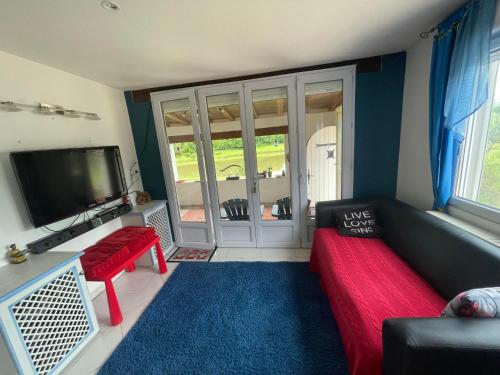 a living room with a couch and a flat screen tv at GÎte VEGA in Mialet