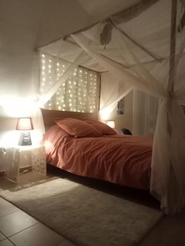 une chambre avec un lit à baldaquin dans l'établissement petite maison avec jardin calme, au Thor