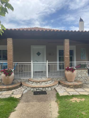 a house with two flower pots in front of it at Mama’s Sunshine Garden Villa in Áyios Ilías