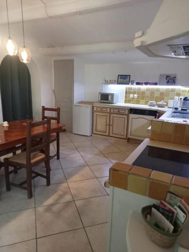 une cuisine avec une table et une salle à manger dans l'établissement petite maison avec jardin calme, au Thor