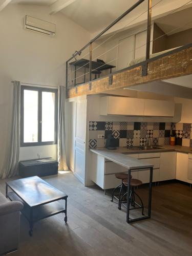 Il comprend une cuisine et un salon avec une mezzanine. dans l'établissement Le Loft de Roxane Centre historique Aix en Provence, à Aix-en-Provence