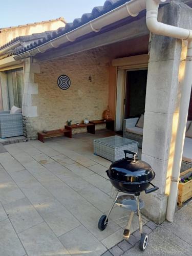 - un barbecue sur une voiturette sur une terrasse dans l'établissement petite maison avec jardin calme, au Thor