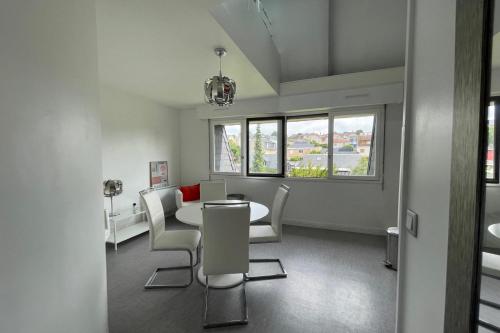 une salle à manger blanche avec une table et des chaises dans l'établissement Nice 2 rooms near Gare de Trouville - Deauville, à Trouville-sur-Mer