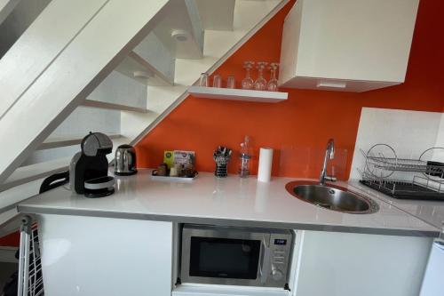 une cuisine avec un évier et un micro-ondes dans l'établissement Nice 2 rooms near Gare de Trouville - Deauville, à Trouville-sur-Mer