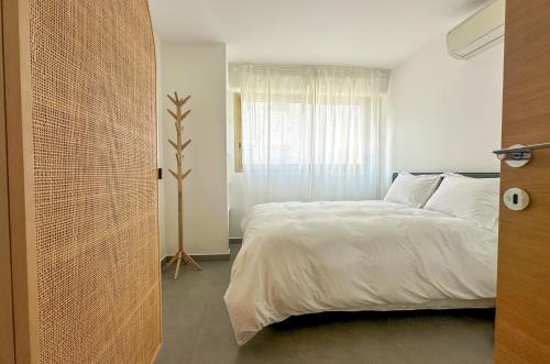 une chambre avec un lit blanc et une fenêtre dans l'établissement Pointe Croisette, Palais & Palm Beach à pied, à Cannes