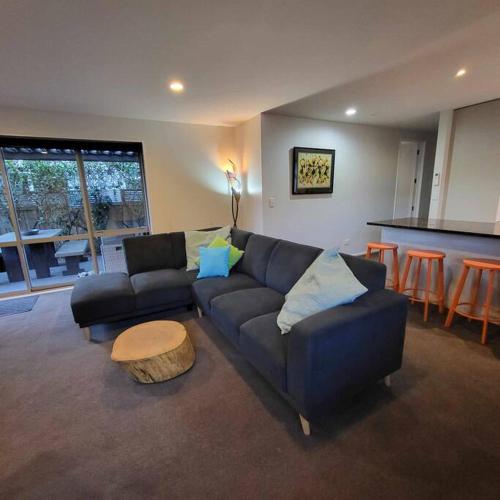 a living room with a couch and a table at Barefoot Beach House Pegasus NZ in Waikuku