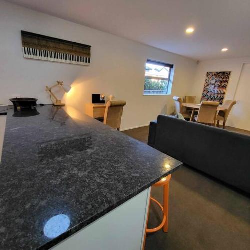 a living room with a black counter top and a couch at Barefoot Beach House Pegasus NZ in Waikuku