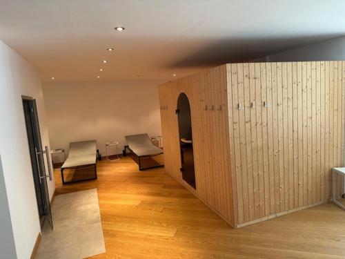a room with two chairs and a wooden wall at Appartament ReLaax in Laax