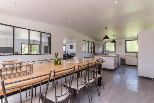 une grande salle à manger avec une longue table et des chaises dans l'établissement Gite de groupe La Laiterie, à Banneville-la-Campagne