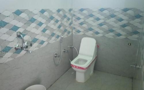 a small bathroom with a toilet and a shower at Sanjay Holiday Home by StayApart in Barkot