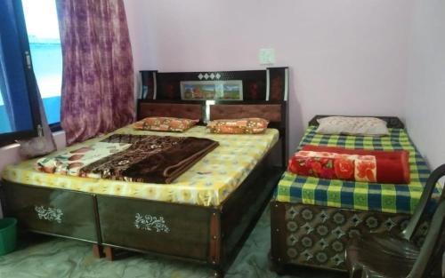 a bedroom with two twin beds and a chair at Sanjay Holiday Home by StayApart in Barkot