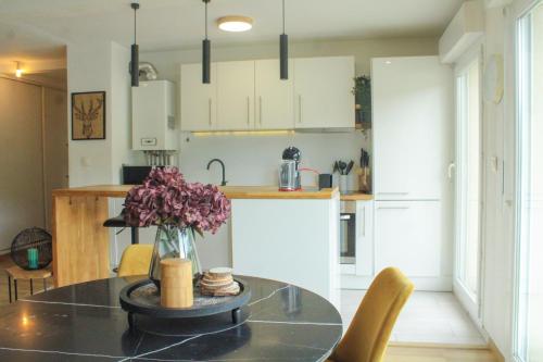 une cuisine avec une table avec un vase de fleurs dessus dans l'établissement TheSkyFall , cosy appartement, terrasse & parking, à Longwy