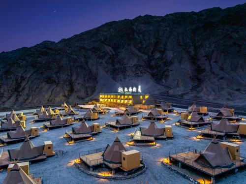 a resort with a bunch of beds and a mountain at 遇见托格伦夏营地 in Taxkorgan