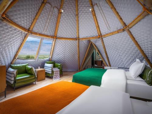 a bedroom in a dome tent with a bed and chairs at 遇见托格伦夏营地 in Taxkorgan