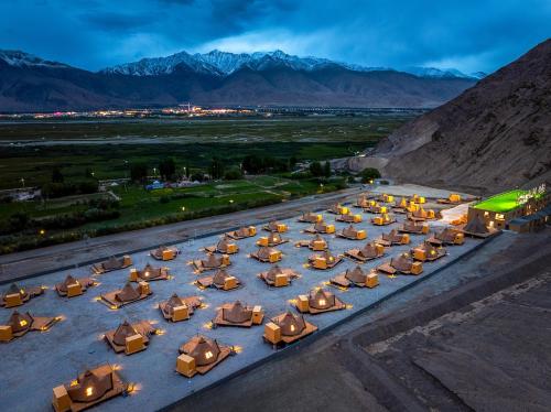 an overhead view of a group of tables and umbrellas at 遇见托格伦夏营地 in Taxkorgan