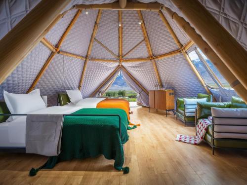a bedroom in a yurt with a bed and chairs at 遇见托格伦夏营地 in Taxkorgan