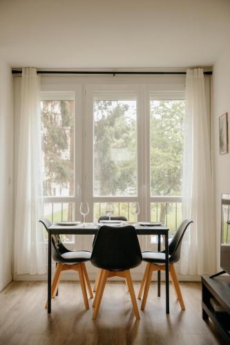 une salle à manger avec une table et des chaises devant une fenêtre dans l'établissement L'escapade Rennaise en bord de vilaine, à Rennes