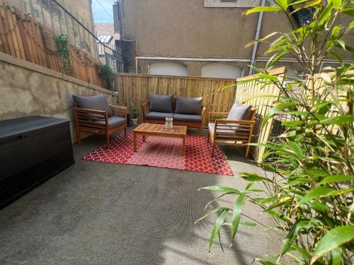 a patio with two chairs and a coffee table at Au Duplex d'Or Centre Historique in Besançon