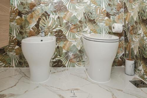 two white toilets sitting on top of a counter at La Loggia Suite in Marsala