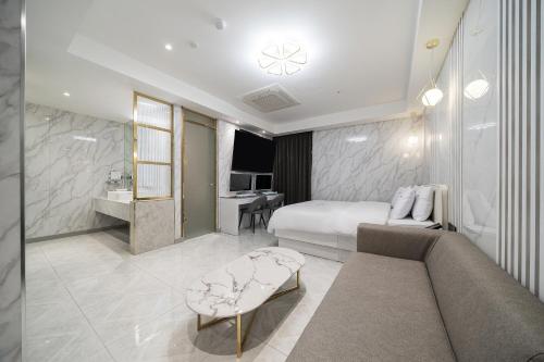 a hotel room with a bed and a couch at Hotel Voll in Seoul