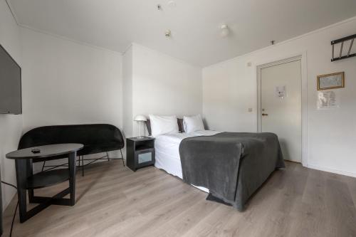 a bedroom with a bed and a table and a chair at Sunde Fjord Hotel, free and easy parking in Solavagen