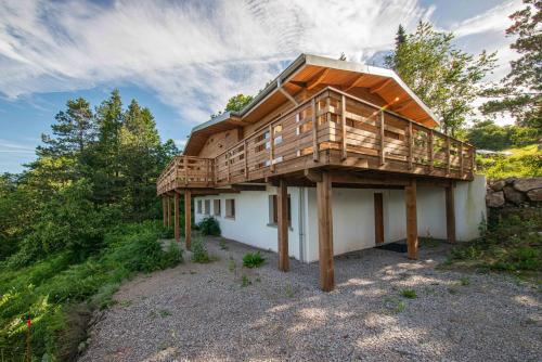 a house with a deck on top of it at Le chalet de l'amicale in Vagney