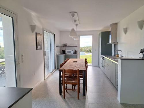 a kitchen with a wooden table and chairs in it at Maison Indépendante avec Piscine in Taulignan