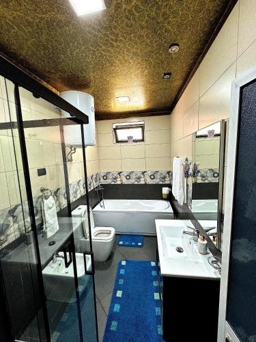 a bathroom with a tub and a sink and a toilet at Vila Darli Peshkopi Dibra in Peshkopi