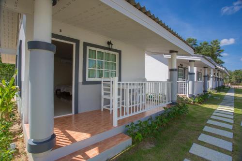 a front porch of a house with a white railing at Suksompong Resort in Khao Lak